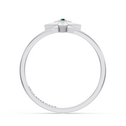 A white gold ring featuring a geometric starburst crown with a small green emerald gemstone at the center and tiny accent stones, shown on a plain white background.