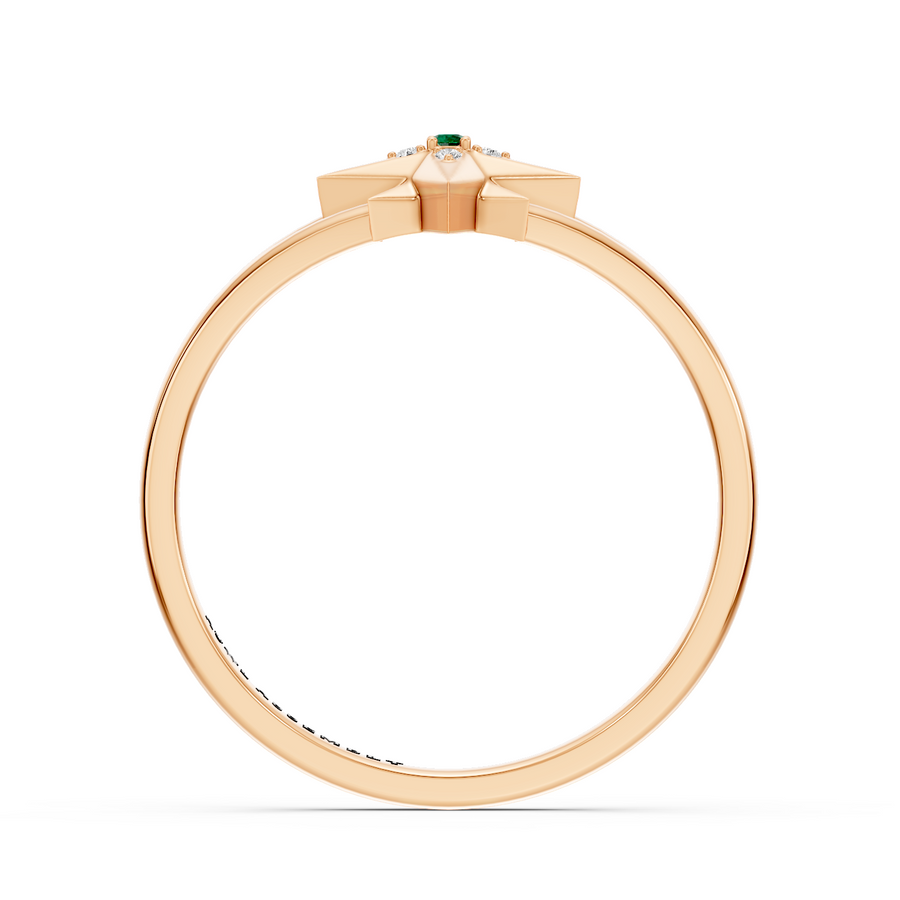 A rose gold ring with a geometric starburst design and a small green emerald center stone, shown on a plain white background.