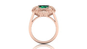Rose gold ring with a green gemstone on a white background