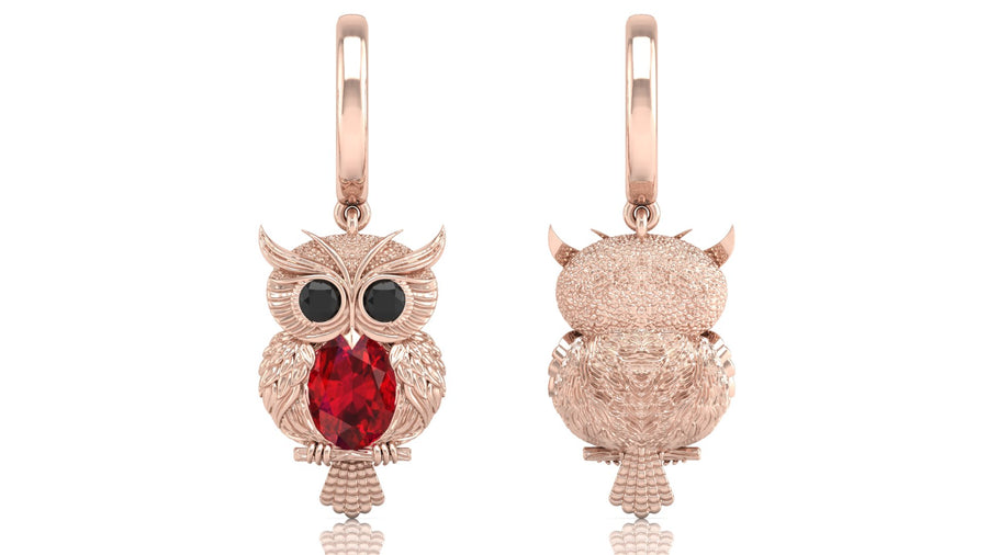 Rose gold owl-shaped earrings with ruby gemstones on a white background