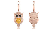 Rose gold owl-shaped earrings with yellow sapphire gemstones on a white background