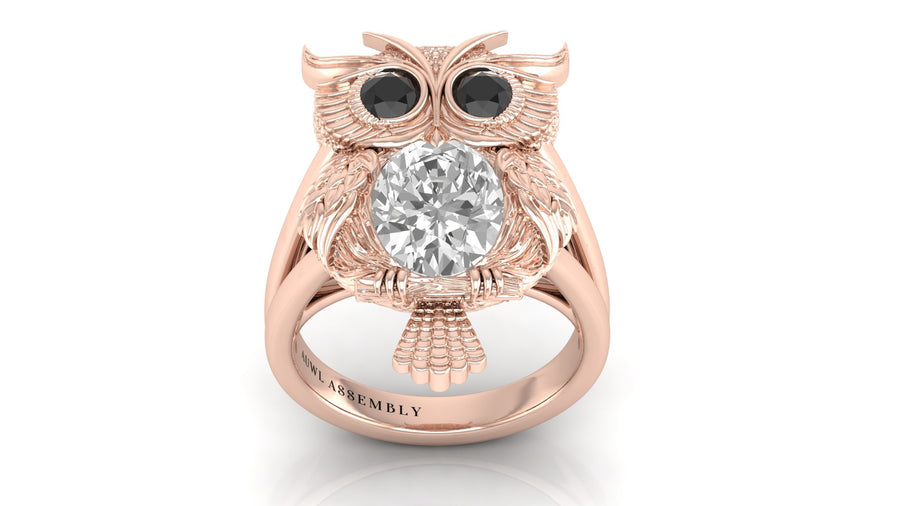 Rose gold owl ring with a diamond gemstone on a white background