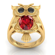 Gold owl-shaped ring with a ruby gemstone on a white background