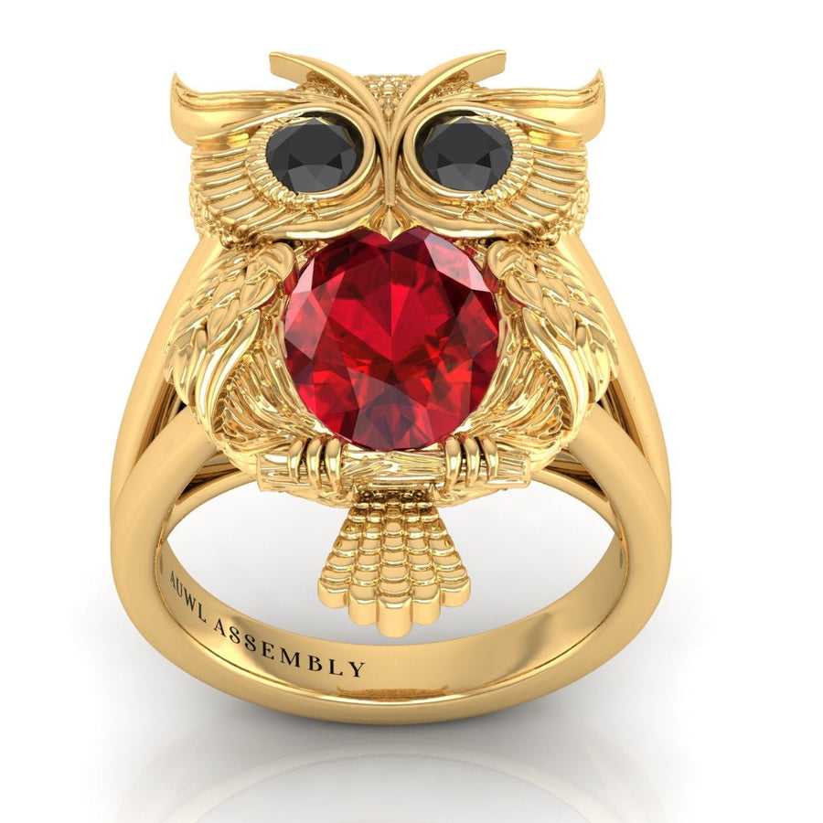 Gold owl-shaped ring with a ruby gemstone on a white background