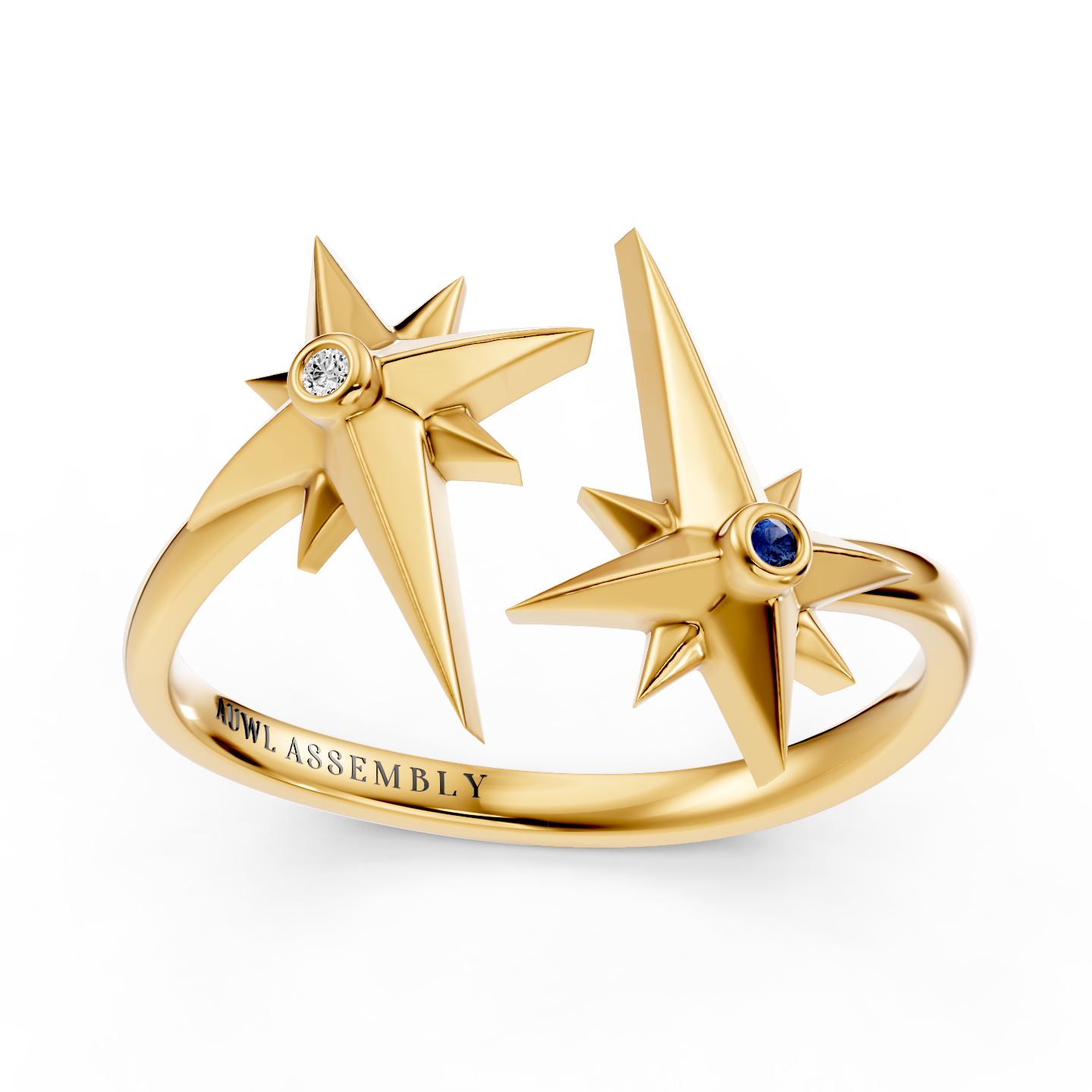 A yellow gold ring featuring two open starburst motifs with one star set with a clear diamond and the other with a small blue sapphire gemstone. The inner band is engraved with 'AUWL ASSEMBLY'.
