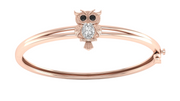 A rose gold bangle bracelet featuring an owl charm with black gemstone eyes and a central Diamond gemstone, shown on a plain white background.