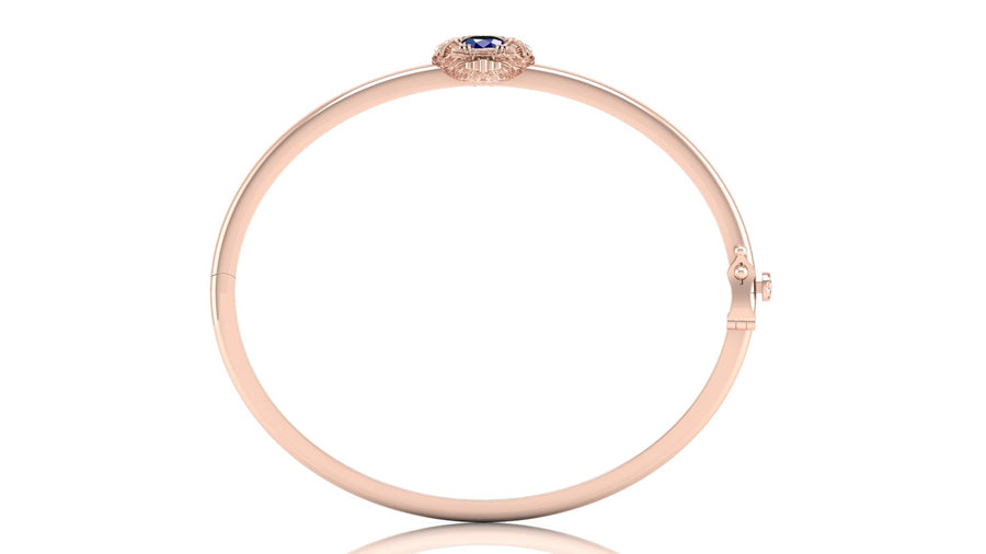 A slim rose gold bangle bracelet with a small Blue sapphire gemstone accent at the top, displayed on a clean white background.