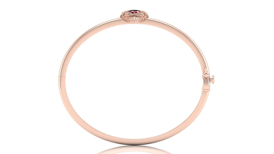 A slim rose gold bangle bracelet with a small oval ruby gemstone and tiny clear accent stones at the top clasp, shown on a white background with a faint reflection.
