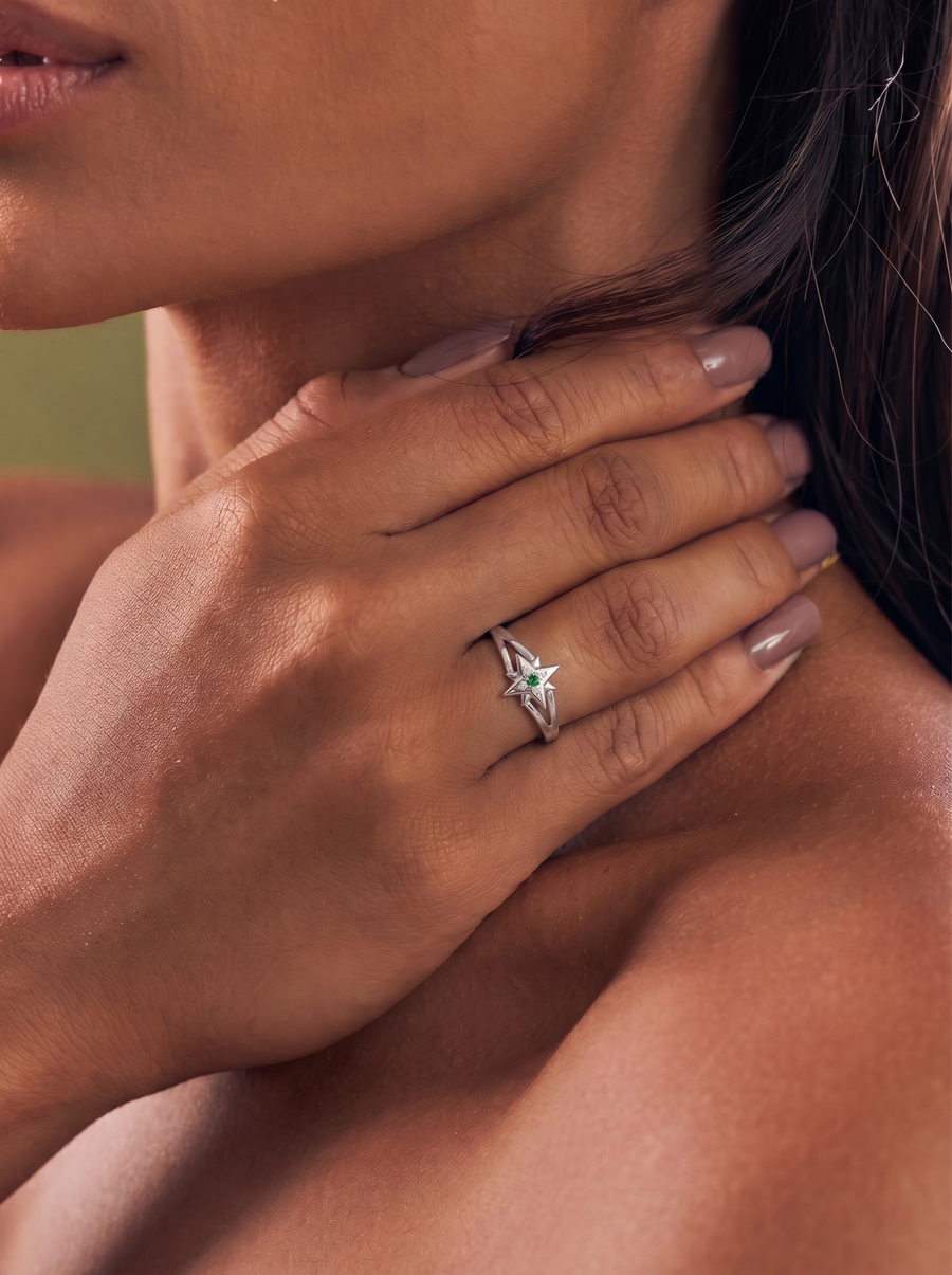 A close-up lifestyle shot of a woman wearing a white gold ring with a star-shaped diamond on her ring finger.