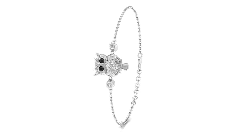 A silver-toned ball chain bracelet featuring a central owl charm with black eyes and clear stones, shown on a plain white background.