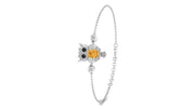 A White gold ball chain bracelet featuring an owl charm with a prominent round yellow Sapphire gemstone on its chest, set against a plain white background.