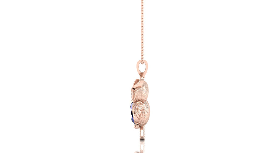 A rose gold pendant necklace featuring a textured owl charm with a small dark blue sapphire gemstone accent, suspended from a delicate rose gold chain against a solid white background.