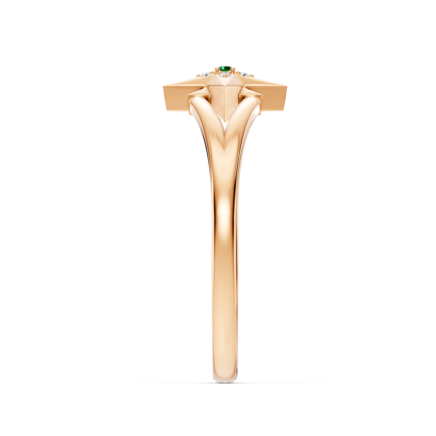A rose gold ring with a unique geometric starburst top featuring a small green emerald gemstone, shown on a plain white background.