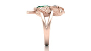 Rose gold ring with emerald stones on a white background