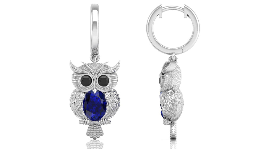 White Gold owl-shaped earrings with blue sapphire gemstones on a white background