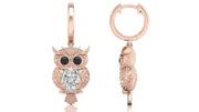 Rose gold owl-shaped earrings with diamond gemstones on a white background