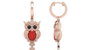 Rose gold owl-shaped earrings with red coral gemstones on a white background