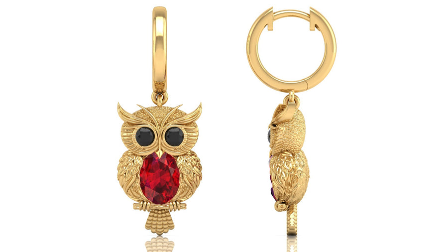Gold owl-shaped earrings with ruby gemstones on a white background