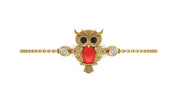 A gold owl pendant bracelet featuring a large red coral-cut center stone, black stone eyes, and small clear accent stones on either side, set on a delicate gold chain against a plain white background.