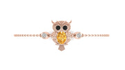 A rose gold owl charm bracelet featuring a central yellow sapphire centrestone and small clear accent stones, displayed on a clean white background.
