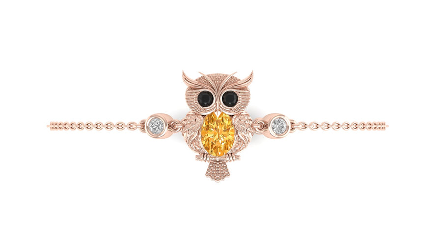 A rose gold owl charm bracelet featuring a central yellow sapphire centrestone and small clear accent stones, displayed on a clean white background.