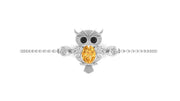 An owl-shaped pendant bracelet in silver-toned metal with a large oval yellow sapphire center stone and small dark eye accents, shown on a plain white background.