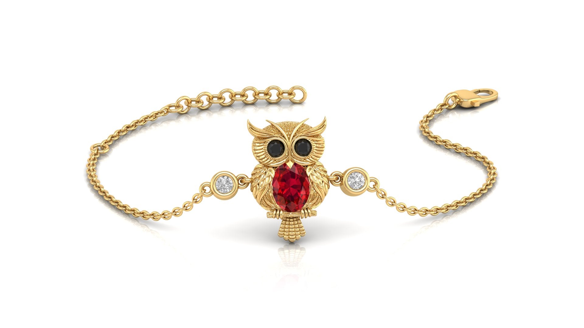 A gold chain bracelet featuring an owl pendant with a red ruby heart, black gemstone eyes, and small clear accent stones, displayed on a clean white background.