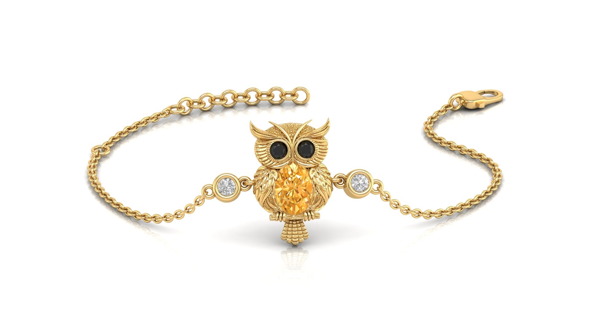 A gold chain bracelet featuring an owl pendant with a Yellow sapphire for a beak, black stones for eyes, and two small clear stones on either side, shown on a white background.