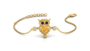 A gold chain bracelet featuring an owl pendant with a Yellow sapphire for a beak, black stones for eyes, and two small clear stones on either side, shown on a white background.