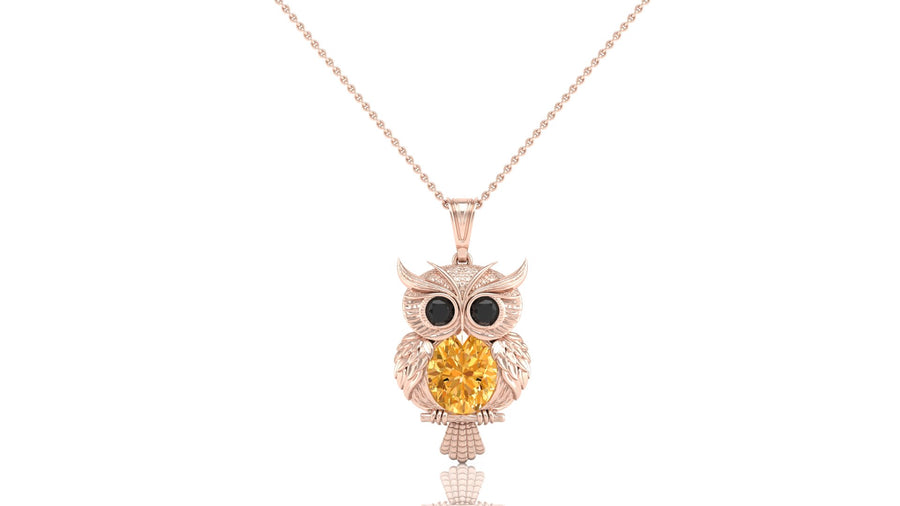 A rose gold owl pendant necklace featuring a large round yellow sapphire gemstone in the center, flanked by small black gemstone eyes, suspended from a delicate rose gold chain against a white background.