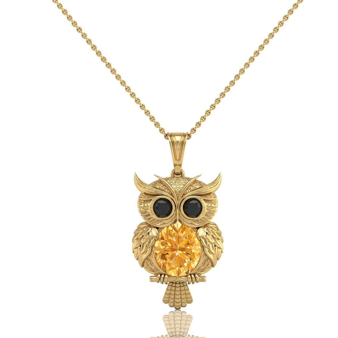 A gold owl pendant necklace featuring a large round yellow sapphire gemstone in the center, flanked by two black gemstone eyes, hanging from a delicate gold chain against a plain white background.