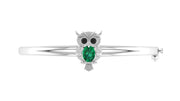 A white gold owl-shaped bangle bracelet featuring a green teardrop-cut gemstone in the center, flanked by small clear stones, shown on a plain white background.
