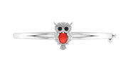 A white gold bangle bracelet featuring an owl charm with a prominent red coral centre oval stone and small clear stones, shown on a plain white background.