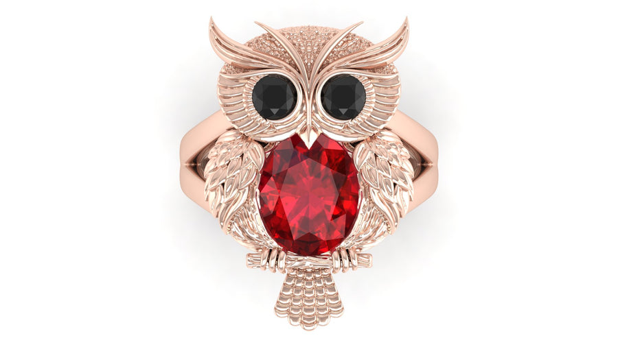 Rose gold owl-shaped brooch with a ruby gemstone on a white background