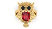 Gold owl-shaped ring with a ruby gemstone on a white background