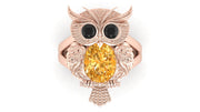 Rose gold owl-shaped brooch with a Yellow sapphire gemstone on a white background
