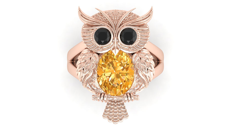 Rose gold owl-shaped brooch with a Yellow sapphire gemstone on a white background
