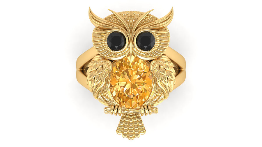 Gold owl-shaped ring with a yellow sapphire gemstone on a white background